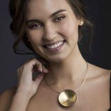 Modellbilde med et forgylt kjempeplanet halskjede og forgylte miniplaneter